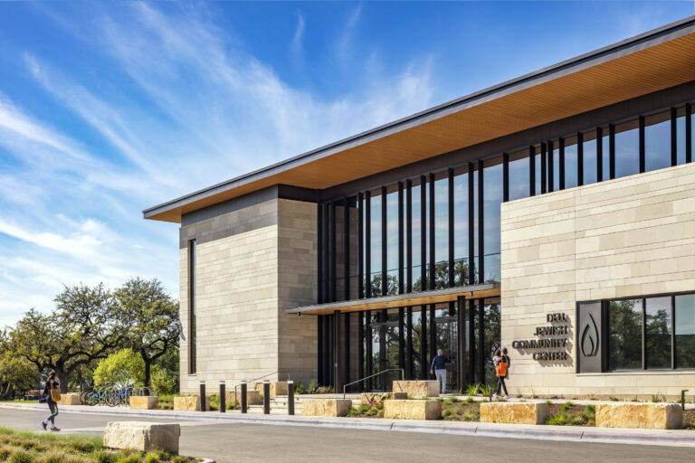 Dell Jewish Community Center Expansion designed by Beck Architecture
Beck provided master planning, architecture, and interior design for the Dell Jewish Community Center. The project spanned multiple phases and included the renovation and expansion of multiple existing buildings, along with the construction of new community, fitness, aquatics and tennis facilities.  Beck’s design focused on creating vibrant spaces that prioritized places for gathering, sustainability and resilience, while infusing meaning into the architecture itself, inspired by the rich cultural heritage of the Jewish people.
The final phase provided a 40,000 SF community and fitness building, which now serves as the main entry for the community center.  The design takes inspiration both from local design strategies and materiality, while infusing meaning from Jewish culture. The building includes a new coffee shop, multi-purpose meeting rooms, an upgraded fitness center, and Shalom Austin’s offices. This phase also included an aquatics expansion and a new tennis facility with a lap pool, play pool, water slides, and concessions building, as well as six outdoor tennis courts.

Beck’s work on the Dell Jewish Community Center is a testament to their expertise and dedication to excellence in architectural design and planning. The project’s impact will be felt for years to come, as the community benefits from the new and improved amenities.