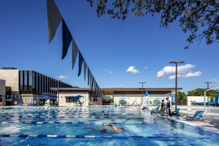 Dell Jewish Community Center Expansion designed by Beck Architecture
Beck provided master planning, architecture, and interior design for the Dell Jewish Community Center. The project spanned multiple phases and included the renovation and expansion of multiple existing buildings, along with the construction of new community, fitness, aquatics and tennis facilities.  Beck’s design focused on creating vibrant spaces that prioritized places for gathering, sustainability and resilience, while infusing meaning into the architecture itself, inspired by the rich cultural heritage of the Jewish people.
The final phase provided a 40,000 SF community and fitness building, which now serves as the main entry for the community center.  The design takes inspiration both from local design strategies and materiality, while infusing meaning from Jewish culture. The building includes a new coffee shop, multi-purpose meeting rooms, an upgraded fitness center, and Shalom Austin’s offices. This phase also included an aquatics expansion and a new tennis facility with a lap pool, play pool, water slides, and concessions building, as well as six outdoor tennis courts.

Beck’s work on the Dell Jewish Community Center is a testament to their expertise and dedication to excellence in architectural design and planning. The project’s impact will be felt for years to come, as the community benefits from the new and improved amenities.